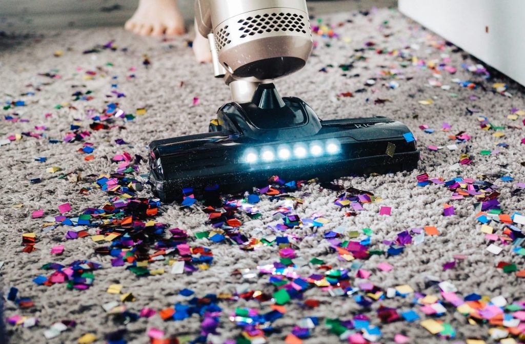 a person using a vacuum to clean a carpet